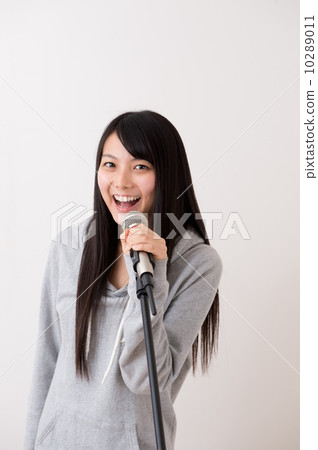 A woman singing with a microphone 10289011
