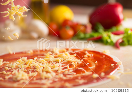Italian pizza preparation with cheese falling. Italian pizza preparation with cheese falling. 10289315