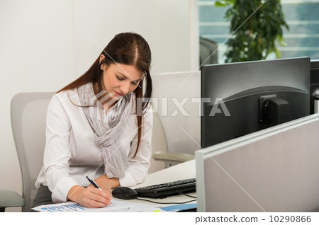 Businesswoman Writing At Desk 10290866