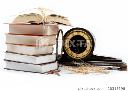 A stack of books and antique clock on a white background. A stack of books and antique clock on a white background. 10318396