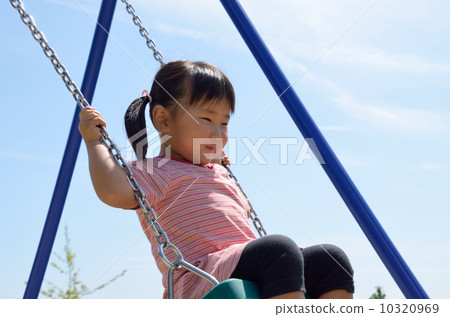 A girl playing with a swing 10320969