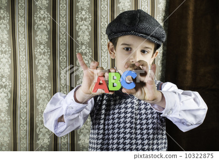 Child in vintage clothes hold letters a b c 10322875