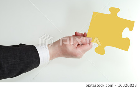 male hand holding yellow puzzle piece male hand holding yellow puzzle piece 10326828