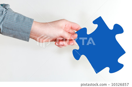 female hand holding blue puzzle piece 10326857