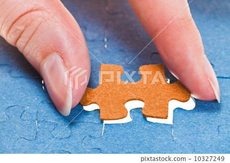 inserting the last orange piece of puzzle inserting the last orange piece of puzzle 10327249