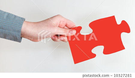 female hand holding red puzzle piece female hand holding red puzzle piece 10327281