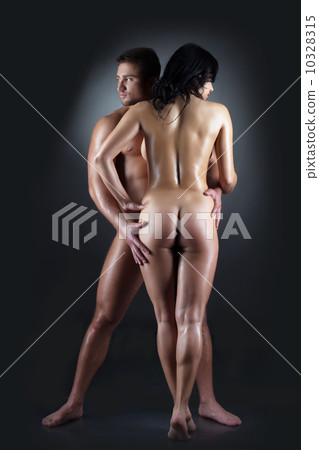 Image of tanned naked partners hugging in studio 10328315