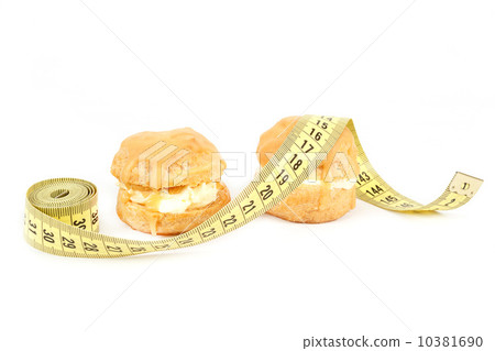 concept of slimming, caramel cakes with measuring tape concept of slimming, caramel cakes with measuring tape 10381690
