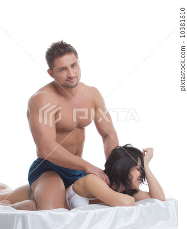 Studio shot of smiling young couple posing in bed 10381810