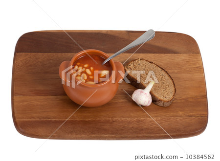 Soup in clay pot with bread and garlic on wooden kitchen board Soup in clay pot with bread and garlic on wooden kitchen board 10384562