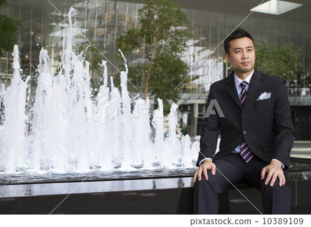 Portrait of Asian business man sitting beside a water fountain Portrait of Asian business man sitting beside a water fountain 10389109