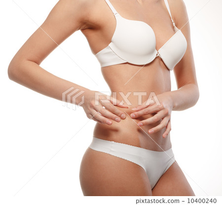 Young woman checks excess weight in their waist. 10400240