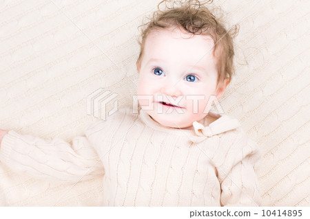 Cute laughing baby girl in a knitted dress Cute laughing baby girl in a knitted dress 10414895