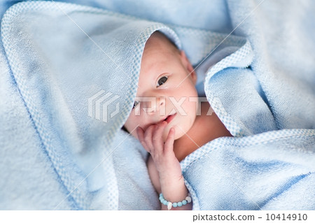 Newborn baby relaxing after a bath in a blue towel Newborn baby relaxing after a bath in a blue towel 10414910
