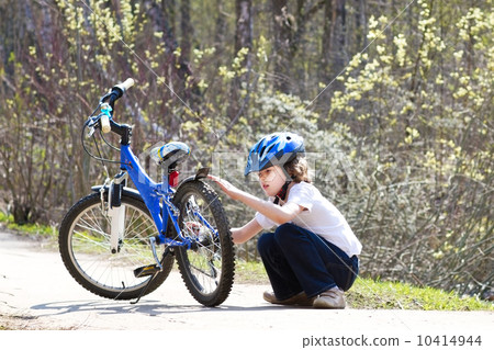 Little boy repairing his bicycle in a park Little boy repairing his bicycle in a park 10414944