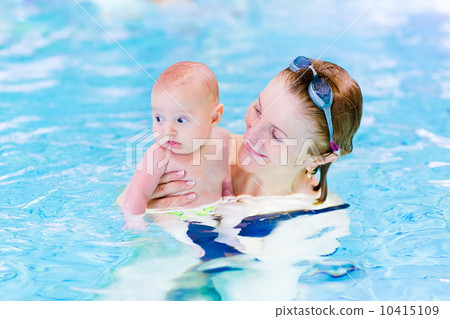 young active woman enjoying swimming pool with a baby boy young active woman enjoying swimming pool with a baby boy 10415109