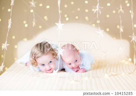 Cute toddler girl and her little newborn baby brother relaxing t 10415285