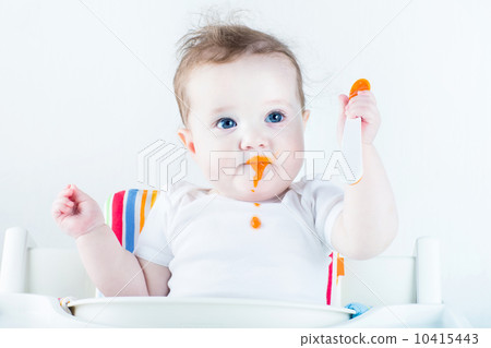 Adorable baby girl eating vegetables for the first time 10415443