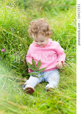 Funny little baby girl playing with a snail in the garden 10415551