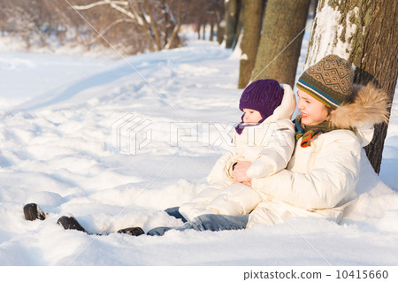 Brother holding his baby sister, playing in the snow 10415660