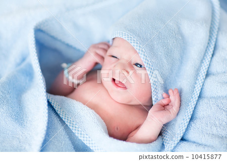 Funny newborn baby covered n a blue bath towel Funny newborn baby covered n a blue bath towel 10415877