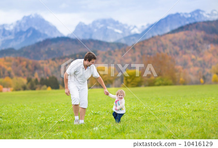 Young happy father playing with his baby daughter in a beautiful Young happy father playing with his baby daughter in a beautiful 10416129