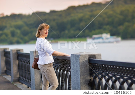 Beautiful lady enjoying the river view in the city center at sun 10416165