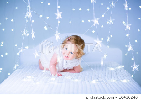 Cute toddler girl with curly hair wearing a white dress playing Cute toddler girl with curly hair wearing a white dress playing 10416246