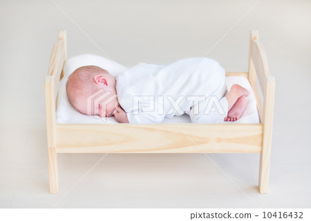 Cute sleeping newborn baby in a toy bed 10416432