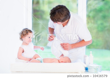 Little toddler girl helping her father to choose an outfit for h 10416579