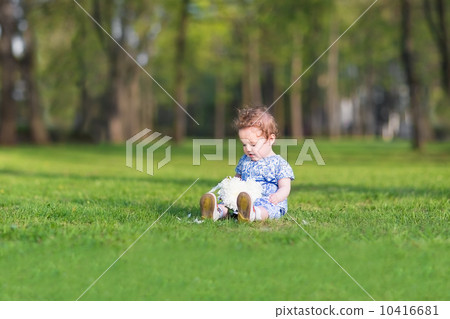 Cute baby girl playing with a big white aster flower 10416681