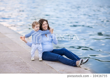 Portrait of a beautiful young pregnant mother and her one year o 10416735