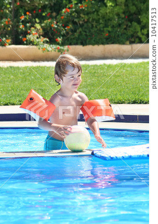Little boy playing with a ball in a swimming pool 10417513