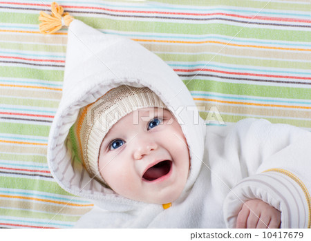 Beautiful little baby with big blue eyes wearing a warm hat and 10417679