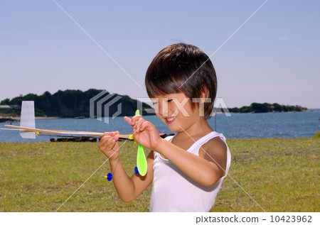 Children flying a model plane on the coast 10423962