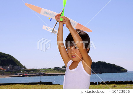 Children flying a model plane on the coast 10423966