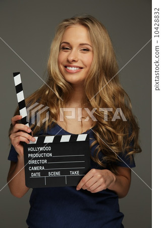Young woman with long hair and blue eyes holding cinema clapper board Young woman with long hair and blue eyes holding cinema clapper board 10428832