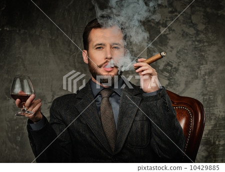 Handsome well-dressed with glass of beverage and cigar 10429885
