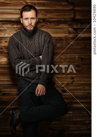 Handsome man wearing cardigan in wooden rural house interior Handsome man wearing cardigan in wooden rural house interior 10429890
