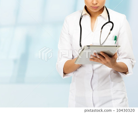 Young brunette doctor woman taking notes on tablet pc 10430320