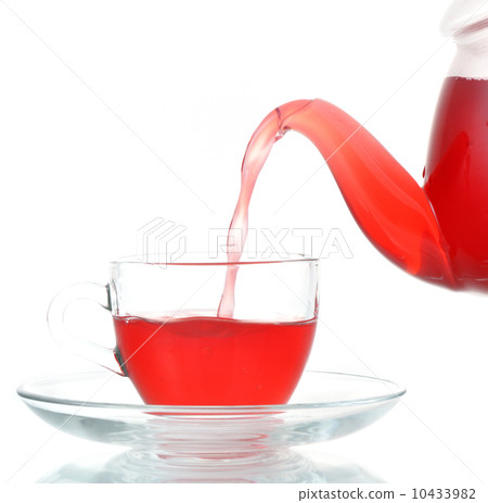 Tea being poured into glass tea cup isolated 10433982