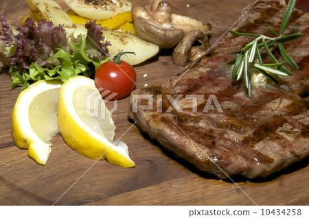 steak grilling on a wooden platter at restaurant steak grilling on a wooden platter at restaurant 10434258