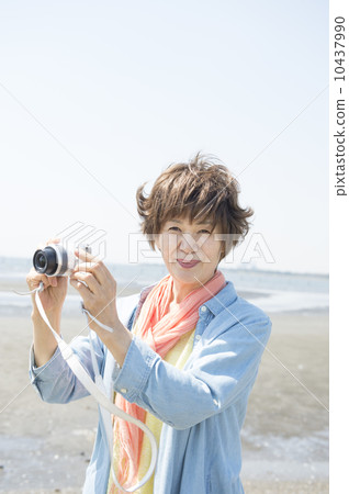 拍照片的資深婦女在海灘 10437990