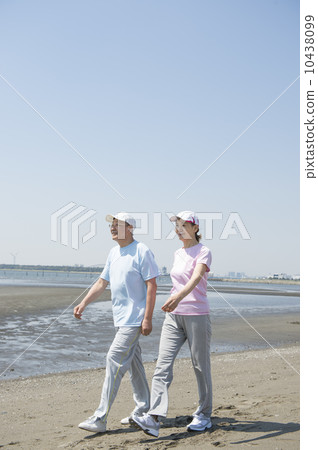 A couple in their 60s walking on the beach 10438099