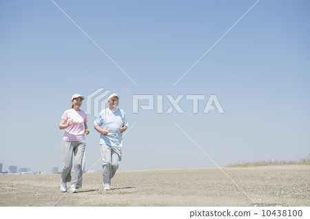 一對60多歲的夫婦在沙灘上慢跑 10438100
