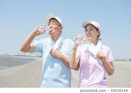 一對60多歲的夫婦在海灘上鍛煉身體 10438144