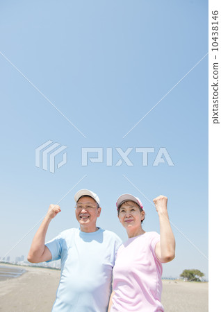 一對60多歲的夫婦在海灘上鍛煉身體 一對60多歲的夫婦在海灘上鍛煉身體 10438146