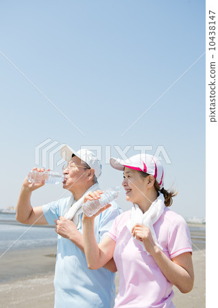 一對60多歲的夫婦在海灘上鍛煉身體 一對60多歲的夫婦在海灘上鍛煉身體 10438147