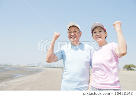 一對60多歲的夫婦在海灘上鍛煉身體 一對60多歲的夫婦在海灘上鍛煉身體 10438148