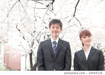 Men and women of suits in front of cherry blossoms Men and women of suits in front of cherry blossoms 10444116